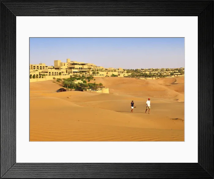 Framed Print : Tourists wander through dunes outside the desert luxury hotel Anantara Qasr Al Sarab Framed Print : Tourists wander through dunes outside the desert luxury hotel Anantara Qasr Al Sarab