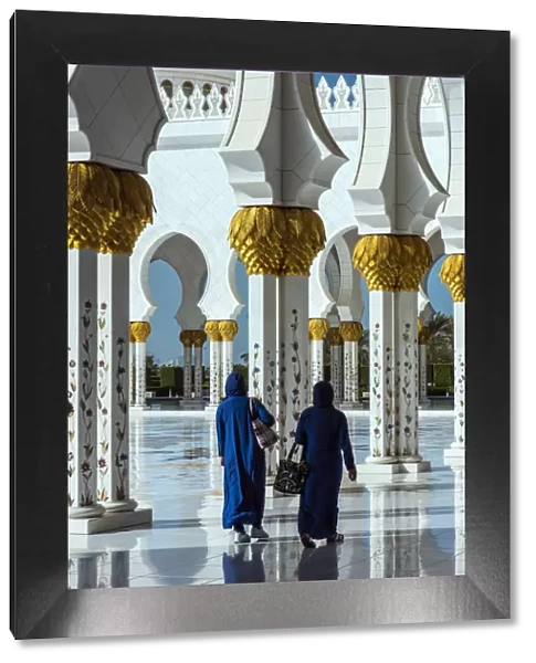 Two Middle Eastern women traditionally dressed walking in the courtyard of the Sheikh