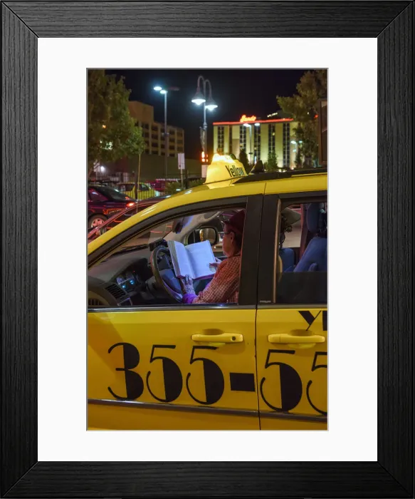 Framed Print : USA, Nevada, Reno, woman cabbie reading in cab at night Framed Print : USA, Nevada, Reno, woman cabbie reading in cab at night