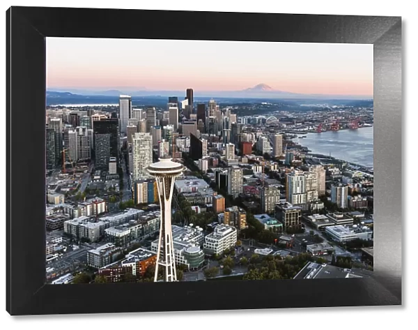 Aerial view of The Space Needle and downtown skyline at sunset with Mt Rainier in