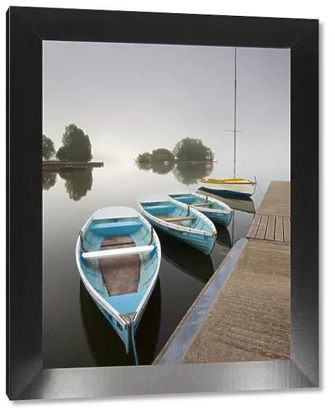 Pleasure boats moored at Llangorse Lake on a misty morning, Brecon Beacons National Park