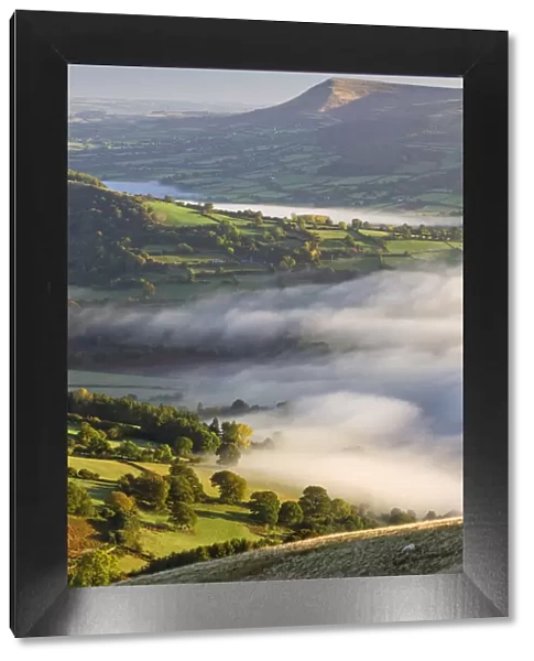 Early morning mist rolls over patchwork countryside in the Brecon Beacons National Park