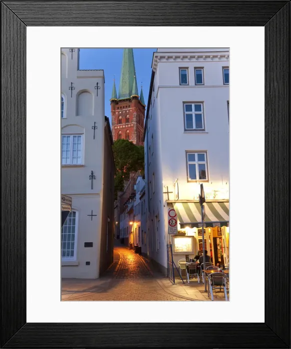 Framed Print : Narrow street to St Petri Church & cafe restaurant at dusk, Lubeck, Germany Framed Print : Narrow street to St Petri Church & cafe restaurant at dusk, Lubeck, Germany