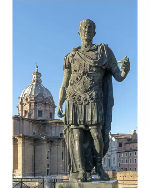 Italy, Lazio, Rome, Via dei Fori Imperiali, statue of Julius Caesar with Church of