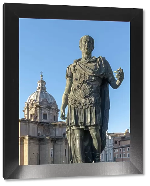 Italy, Lazio, Rome, Via dei Fori Imperiali, statue of Julius Caesar with Church of