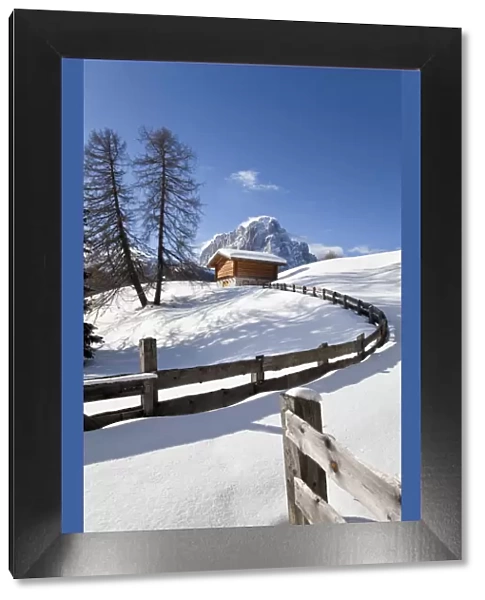Winter snow covered mountain hut in front of Sassolungo mountain (3181m), Val Gardena