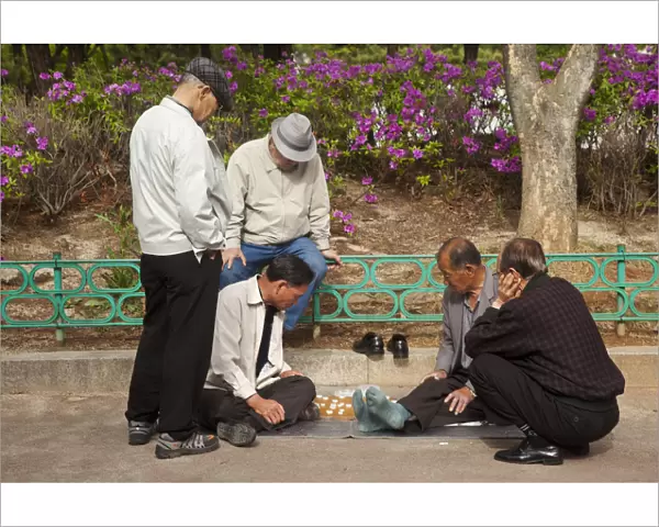 Korea, Seoul, Men playing board game in park outside Jongmyo Shrine