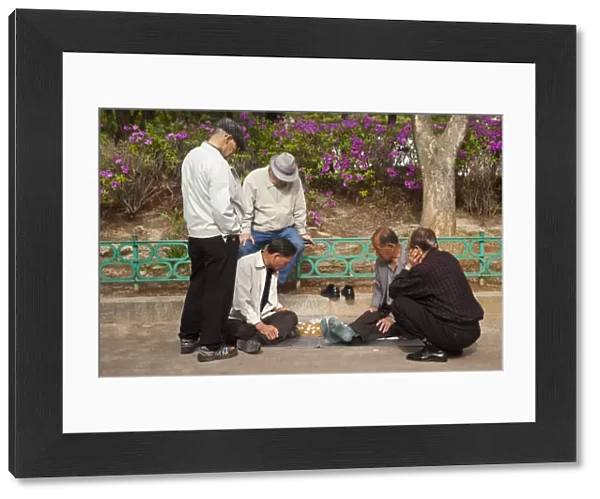 Korea, Seoul, Men playing board game in park outside Jongmyo Shrine