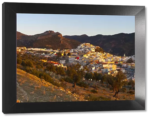Elevated view over the historic hilltop town of Moulay Idriss illuminated at sunset