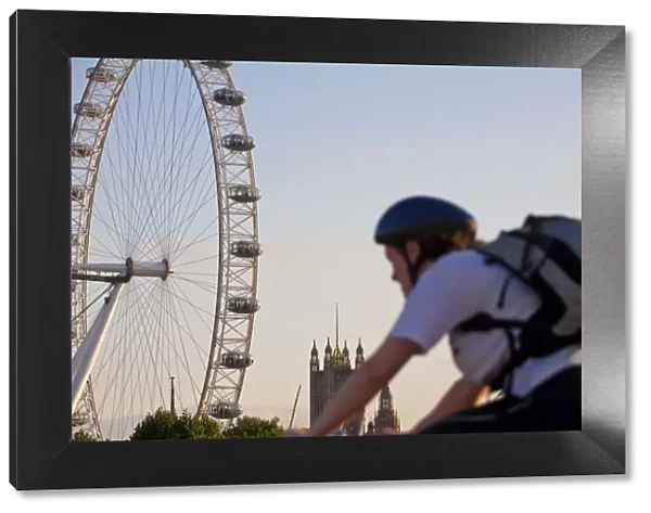 England, London, Westminster, Man cycling with The London Eye & The Houses of Parliament