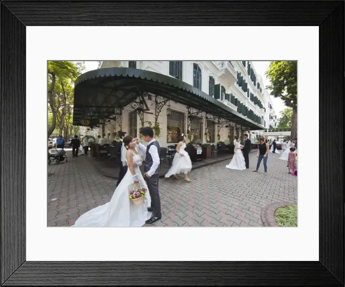Framed Print : Brides and Grooms being photographed infront of the Sofitel Metropole Legend Hotel
