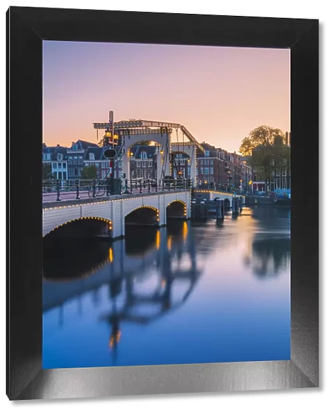 Magere brug at dusk reflecting in the Amstel canal in Amsterdam, Holland  /  Netherlands