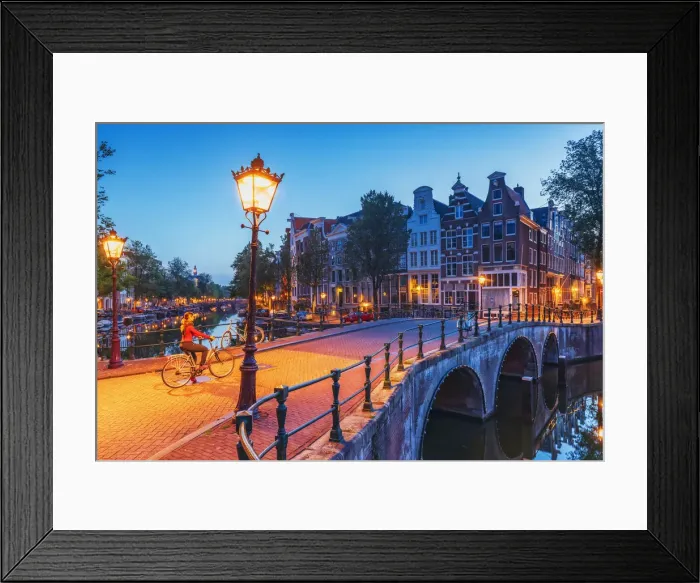 Framed Print : A woman riding a bike by night in Amsterdam along Keizersgracht canal in Amsterdam Framed Print : A woman riding a bike by night in Amsterdam along Keizersgracht canal in Amsterdam