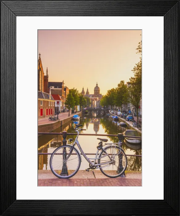 Framed Print : A bike on a bridge with St. Nicholas church in the background at sunrise in Amsterdam Framed Print : A bike on a bridge with St. Nicholas church in the background at sunrise in Amsterdam