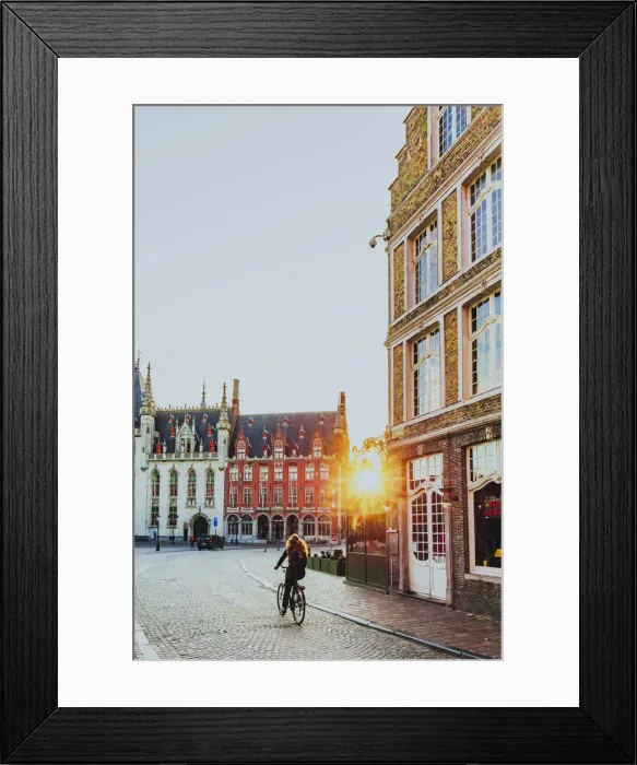 Framed Print : A woman riding a bike in Bruges Market Square at sunrise, Belgium Framed Print : A woman riding a bike in Bruges Market Square at sunrise, Belgium