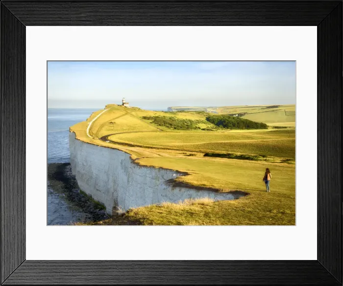 Framed Print : Girl looking at the Seven Sisters Cliffs in the early morning with Belle Tout lighthouse
