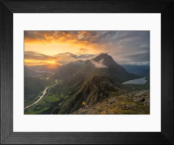 Framed Print : Hiker walking on Romsdalseggen ridge over Rauma valley lit by sun rays at sunset
