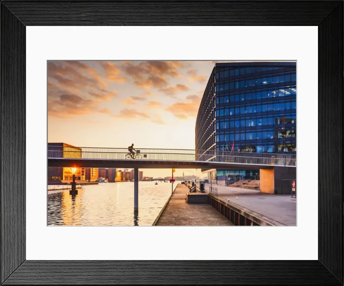Framed Print : A woman riding a bike on the bike bridge over the water canal Framed Print : A woman riding a bike on the bike bridge over the water canal