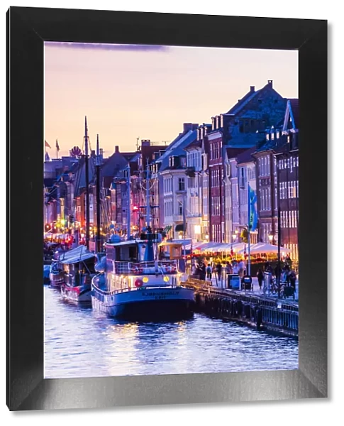 Typical buildings along Nyhavn water canal in Copenhagen by night, Denmark