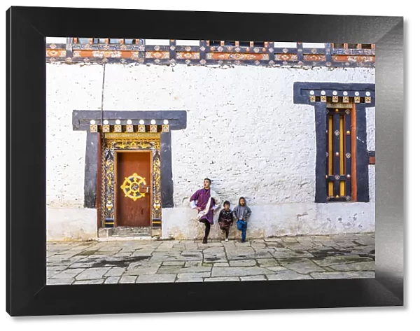 A man and kids standing in Trongsa Dzong, Trongsa District, Bhutan