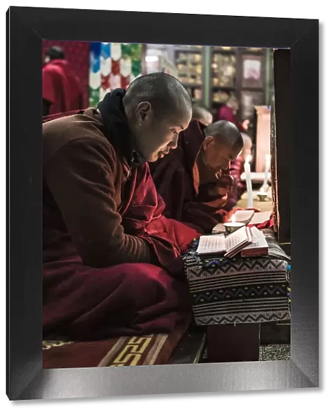 Monks during evening candle light prayer in Lhodrak Kharchu monastery, Jakar