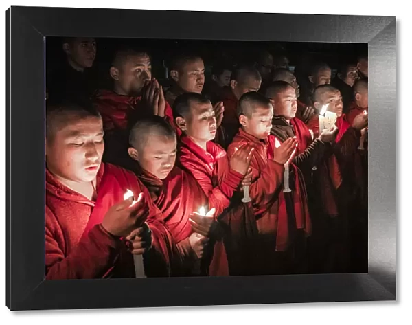 Monks during evening candle light prayer in Lhodrak Kharchu monastery, Jakar