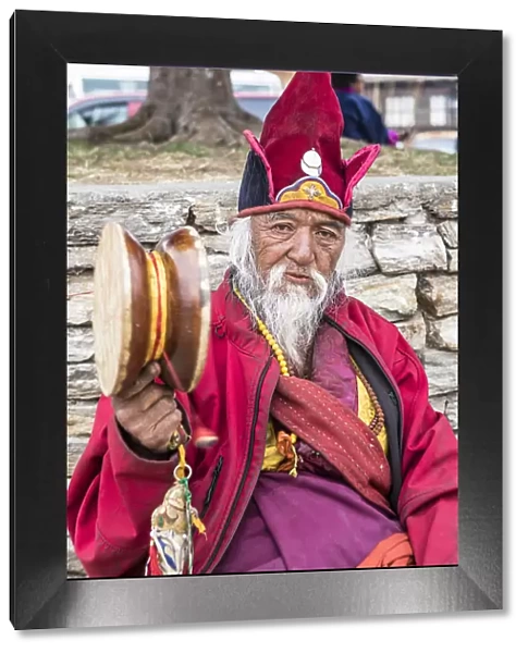 A priest sitting outside Punakha Dzong, Punakha, Punakha District, Bhutan