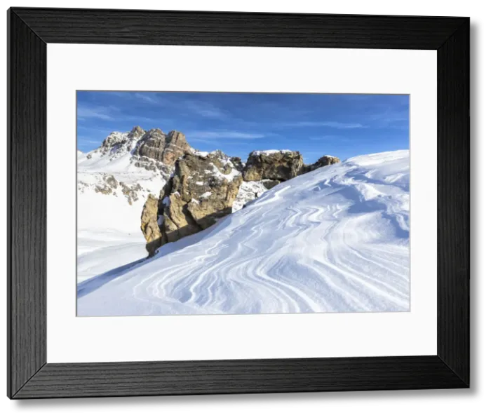 Framed Print : One person above a rock natural arch with snow shaped by the wind in the foreground Framed Print : One person above a rock natural arch with snow shaped by the wind in the foreground