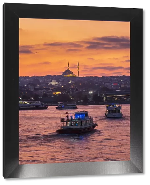 Boats in the Golden Horn at sunset with a Mosque in the background. Istanbul, Turkey