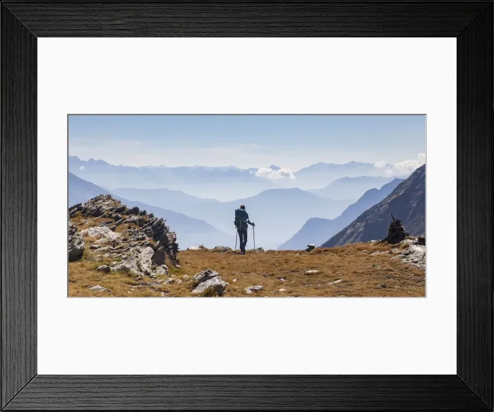 Framed Print : Hiker looking to the mountainscape and mountain profiles in background in Swiss Alps Framed Print : Hiker looking to the mountainscape and mountain profiles in background in Swiss Alps