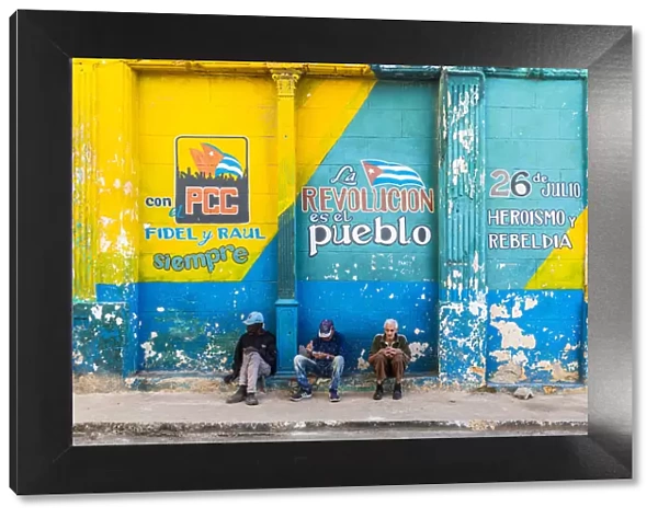 People sitting on a street corner in La Habana Vieja (Old Town), Havana, Cuba