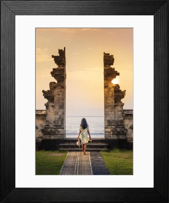 Framed Print : Indonesia, Bali, Candidasa. A young woman walking through the doorway of a traditional Framed Print : Indonesia, Bali, Candidasa. A young woman walking through the doorway of a traditional