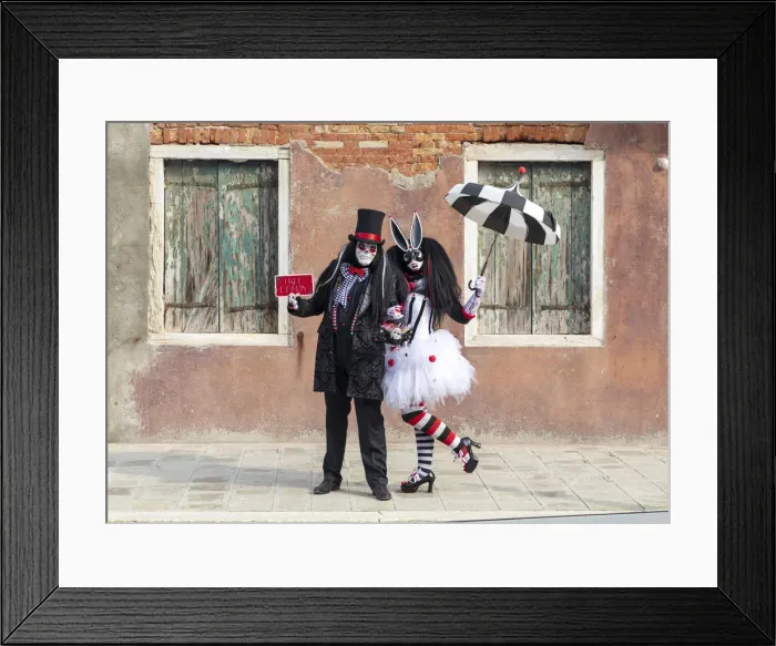 Framed Print : Two people pose in front of a colourful facade on Burano during the Venice Carnival Framed Print : Two people pose in front of a colourful facade on Burano during the Venice Carnival