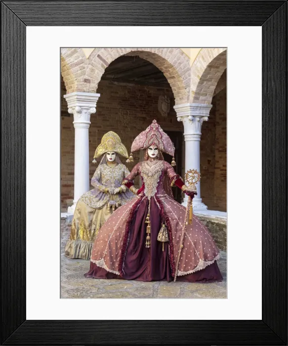 Framed Print : Two women wearing Indian style costumes and masks pose in the cloisters of Chiesa di San Framed Print : Two women wearing Indian style costumes and masks pose in the cloisters of Chiesa di San