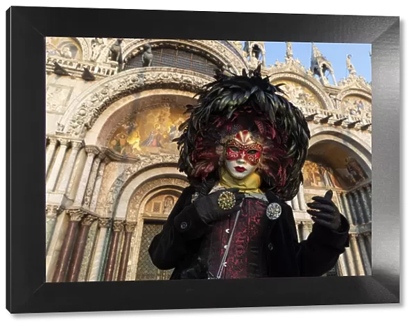 A woman in costume stands in front of the Basilica San Marco in St