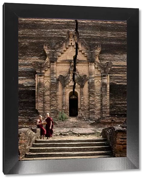 Two novice monks reading a book in front of entrance to Pahtodawgyi pagoda, Mingun