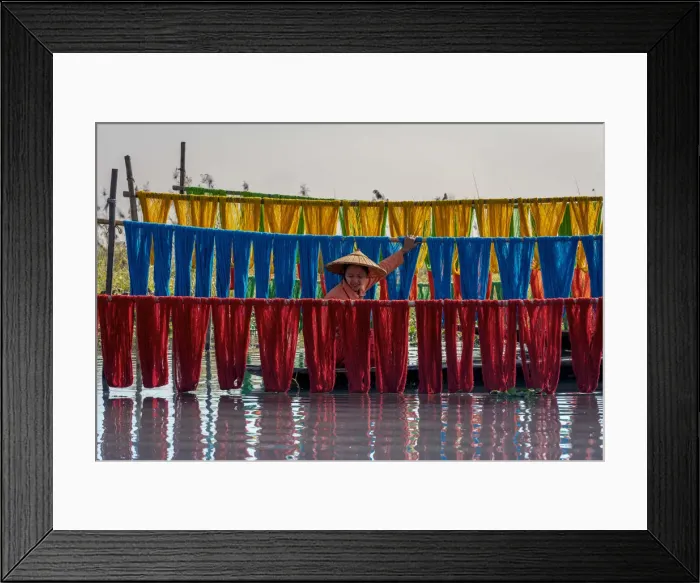 Framed Print : Woman hanging dyed yarn from a boat to dry in a traditional weaving village on Lake Inle Framed Print : Woman hanging dyed yarn from a boat to dry in a traditional weaving village on Lake Inle