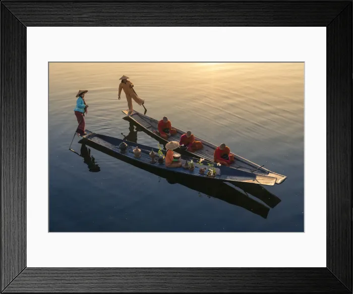 Framed Print : A woman on a boat giving rice as alms to three monks sitting on a boat at sunrise Framed Print : A woman on a boat giving rice as alms to three monks sitting on a boat at sunrise