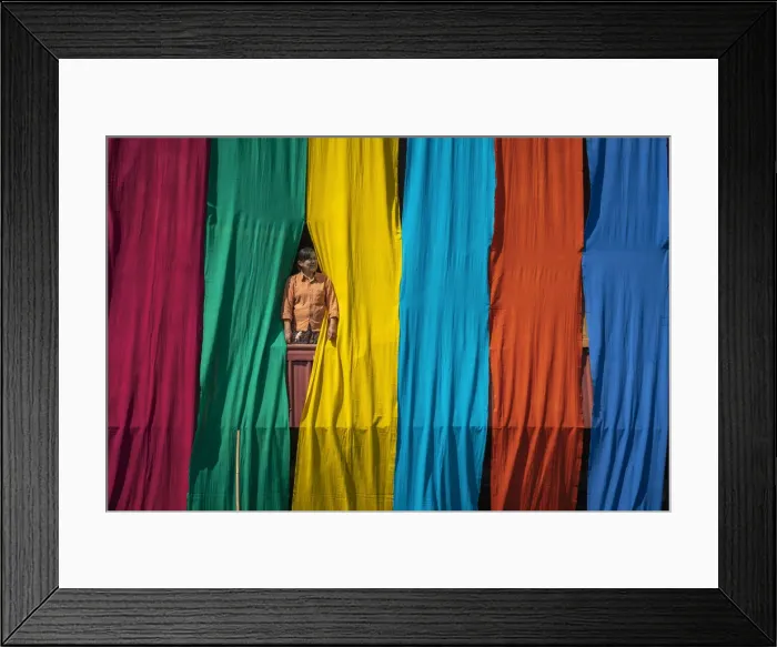 Framed Print : Woman in a window checking freshly dyed fabric hanging from bamboo poles to dry on a Framed Print : Woman in a window checking freshly dyed fabric hanging from bamboo poles to dry on a