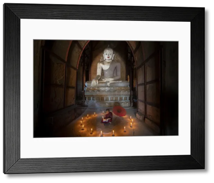Framed Print : Novice monk studying inside a temple under big Buddha statue, UNESCO, Bagan Framed Print : Novice monk studying inside a temple under big Buddha statue, UNESCO, Bagan
