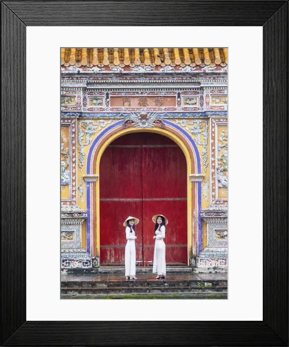 Framed Print : Southeast Asia, Vietnam, Hue. Two young women wearing Ao Dai dresses stand next to an Framed Print : Southeast Asia, Vietnam, Hue. Two young women wearing Ao Dai dresses stand next to an