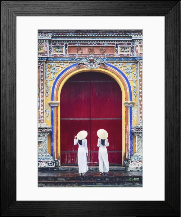 Framed Print : Southeast Asia, Vietnam, Hue. Two young women wearing Ao Dai dresses stand next to an Framed Print : Southeast Asia, Vietnam, Hue. Two young women wearing Ao Dai dresses stand next to an