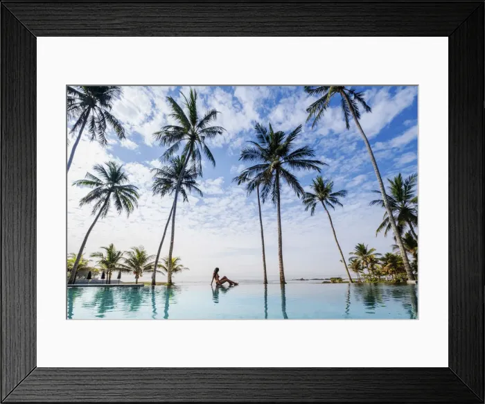 Framed Print : Indonesia, Bali, Candidasa. A young woman sitting on the edge of an infinity swimming Framed Print : Indonesia, Bali, Candidasa. A young woman sitting on the edge of an infinity swimming
