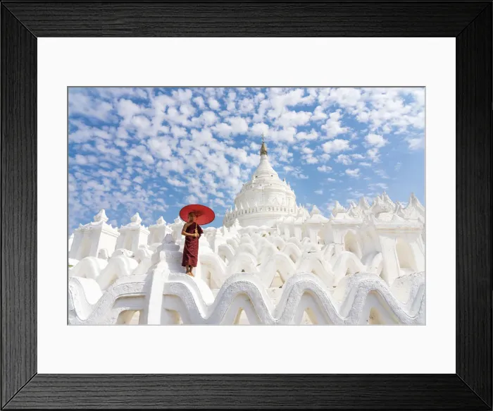 Framed Print : Novice monk with an umbrella standing at white Hsinbyume pagoda
