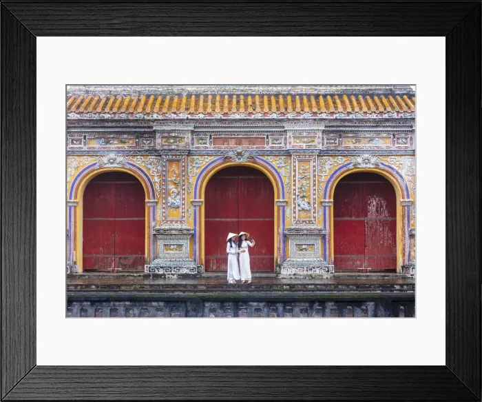 Framed Print : Southeast Asia, Vietnam, Hue. Two young women wearing Ao Dai dresses stand next to an Framed Print : Southeast Asia, Vietnam, Hue. Two young women wearing Ao Dai dresses stand next to an