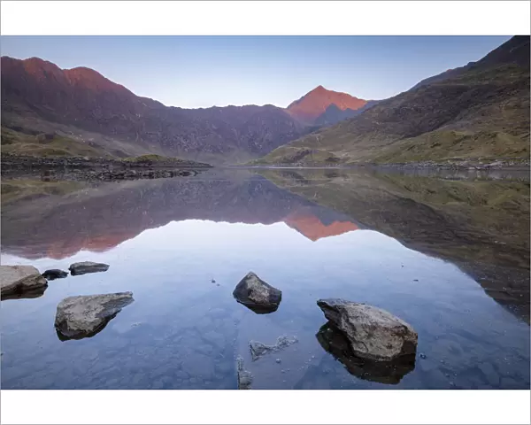 Mount Snowdon bathed in the first light of dawn and reflected in Llyn Llydaw