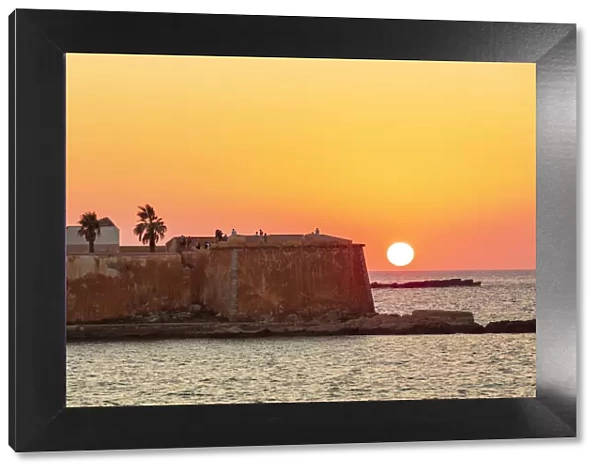 Trapani, Sicily. Seascape of the Ligny tower with the sun setting in the sea