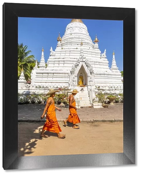 Two monks walking past a stupa in Wat Phan On temple complex, Chiang Mai