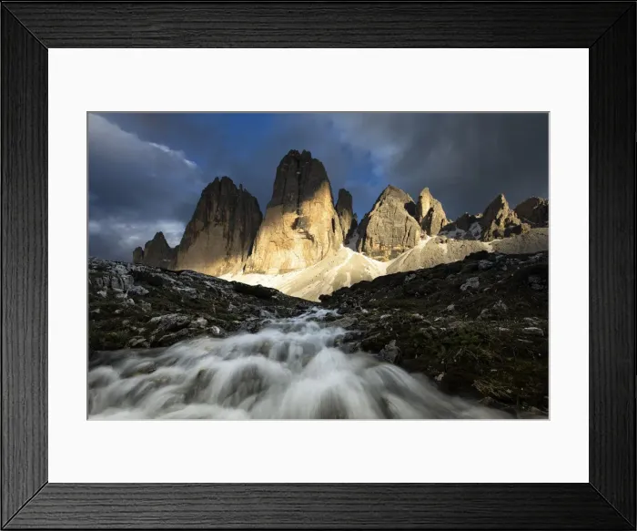 Framed Print : a warm light filters through the clouds and envelops the Tre Cime di Lavaredo during a Framed Print : a warm light filters through the clouds and envelops the Tre Cime di Lavaredo during a