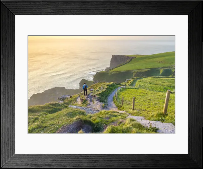 Framed Print : A tourist admiring the view of a sunset at the Cliffs of Moher Framed Print : A tourist admiring the view of a sunset at the Cliffs of Moher